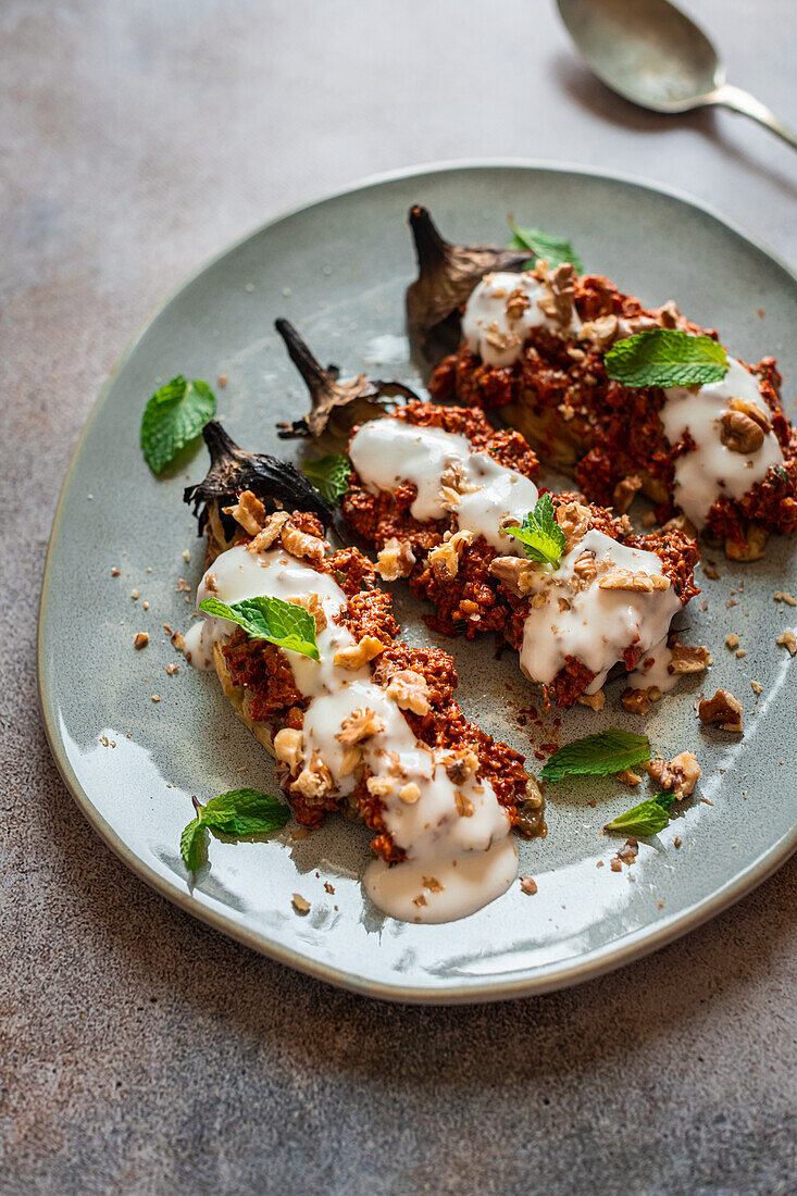 Geröstete Aubergine mit Muhammara, Toum, Minze und Walnüssen