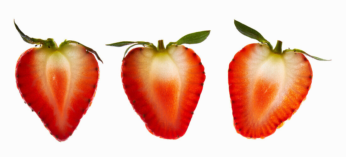 Halbierte Erdbeeren vor weißem Hintergrund