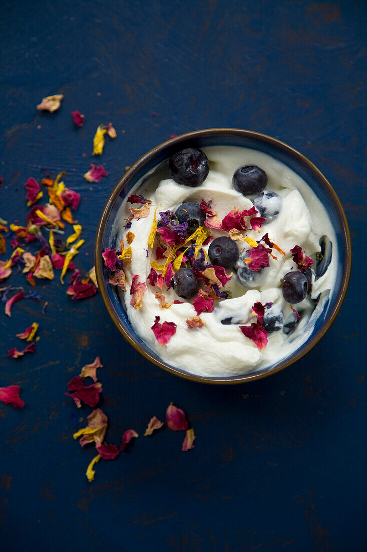 Yoghurt and blueberries with edible flowers