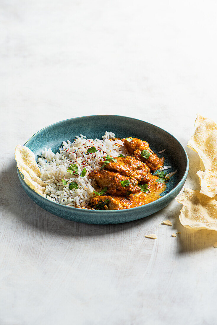 Butter chicken curry (murgh makhani) with rice and coriander