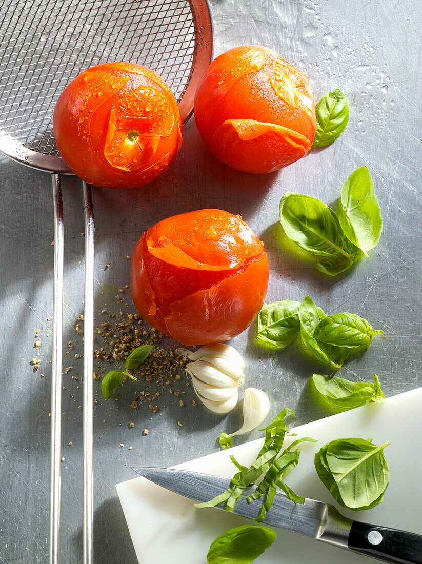 Blanchierte Tomaten daneben Basilikum und Knoblauch