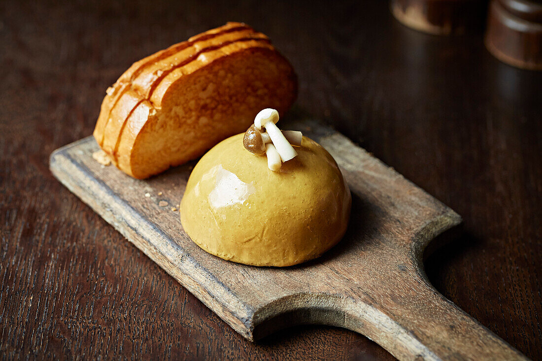 A mushroom pie and brioche toast on a wooden board