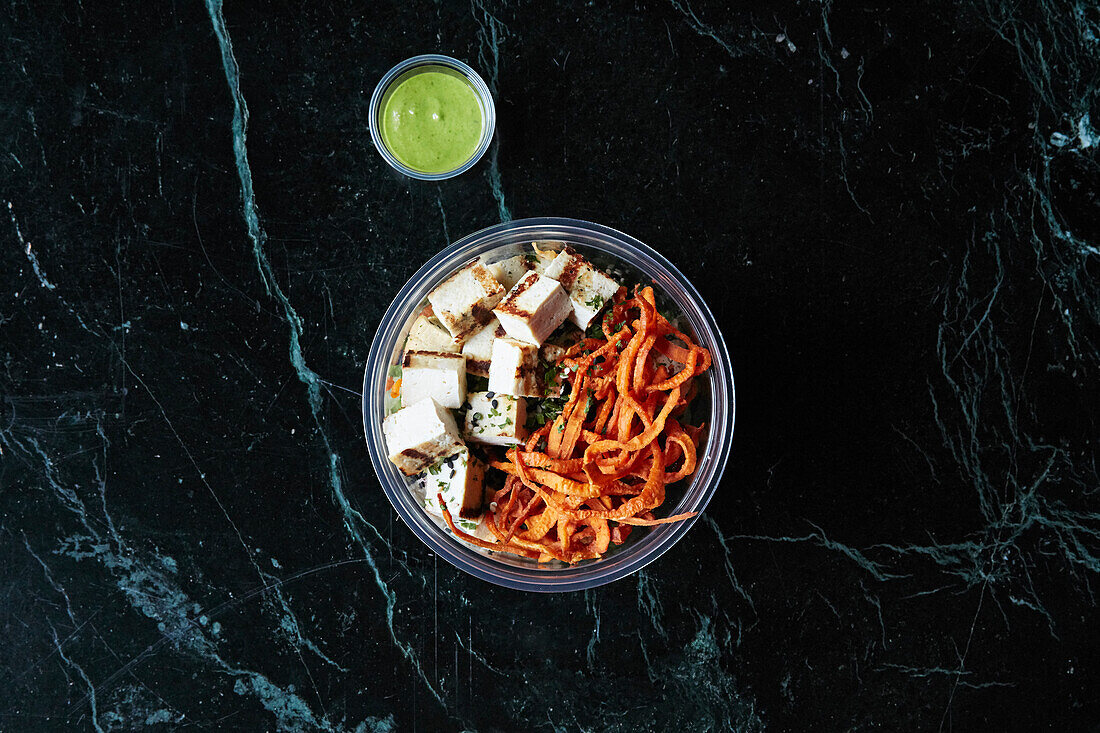 Gesunde Bowl mit Tofu und knuspriger Süßkartoffel zum Mitnehmen