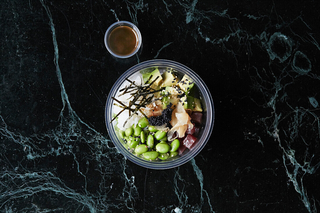 Gesunde Bowl mit Reis, Thunfisch, Avocado und Edamame zum Mitnehmen