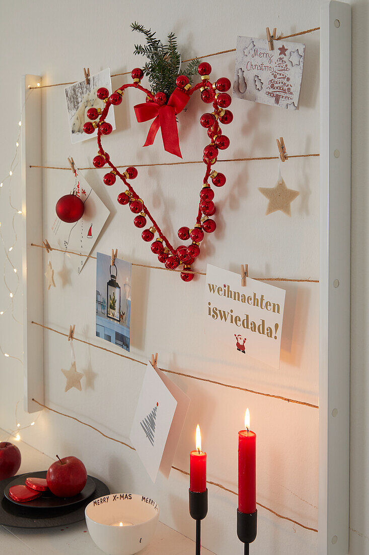 Weihnachtlich dekoriertes Memoboard und rote Kerzen