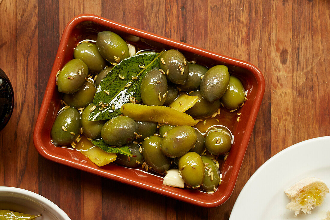 Grüne Oliven in Öl mit Zitrone und Kreuzkümmel