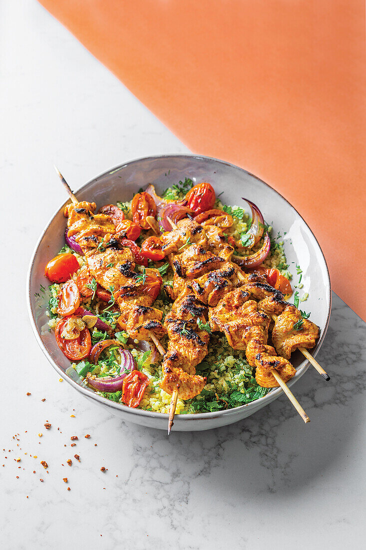 Chicken skewers with roasted tomatoes and bulgur wheat