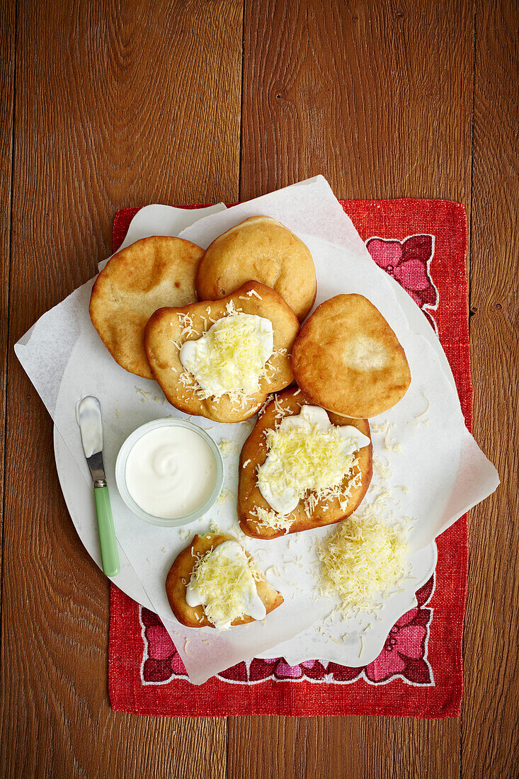 Langos - Ungarisches frittiertes Kartoffelfladenbrot mit Sauerrahm und Käse