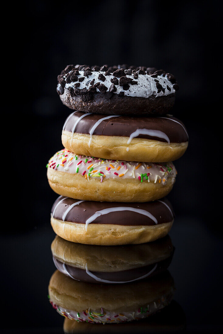A stack of doughnuts against a black background