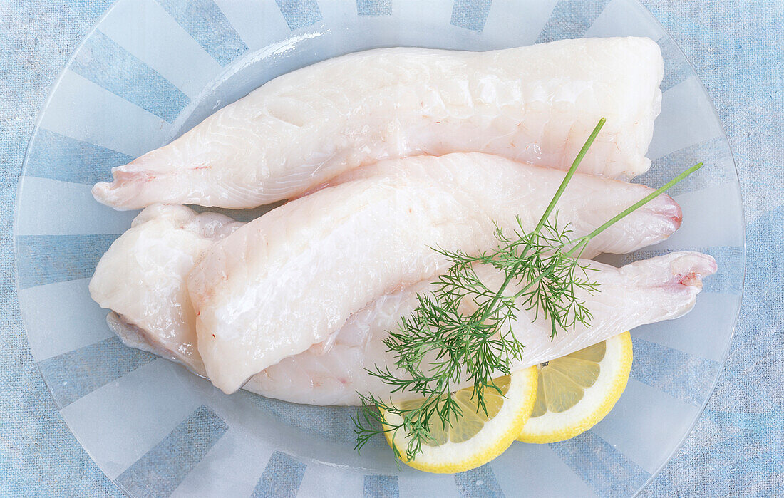 Three monkfish fillets with lemon slices and dill