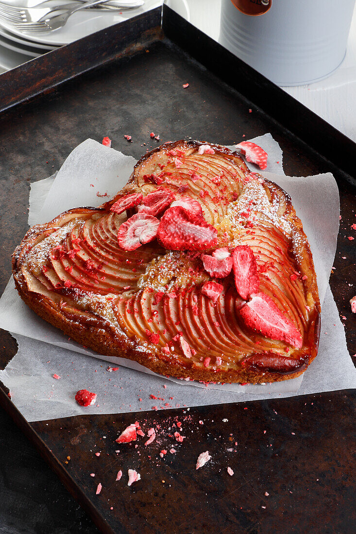 Herzförmiger Kuchen mit Äpfeln, bestreut mit getrockneten Erdbeeren