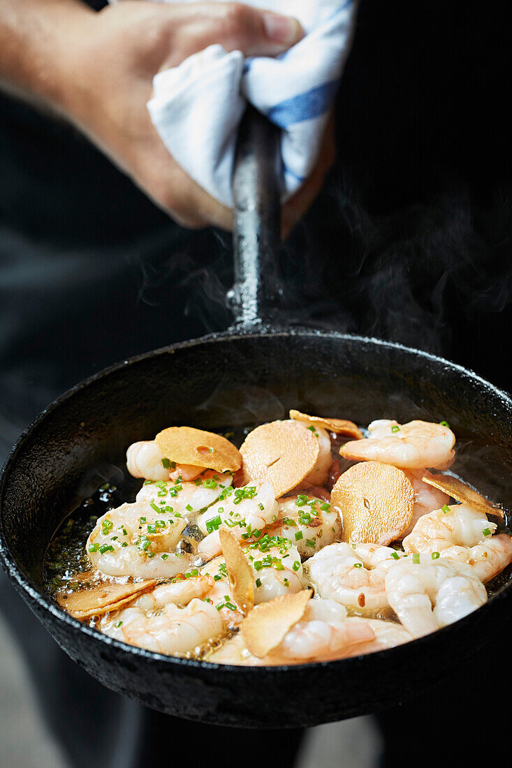 Fried king prawns in garlic oil in a frying pan