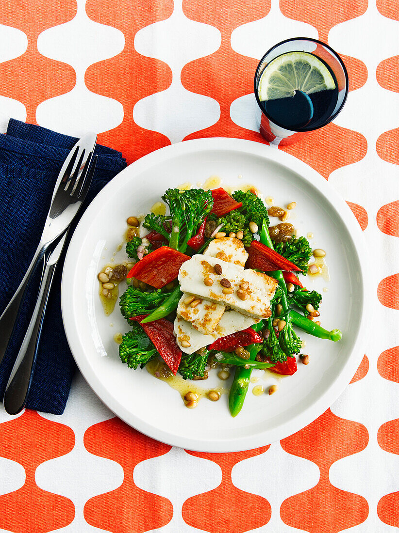 Broccoli salad with peppers, pine nuts and halloumi