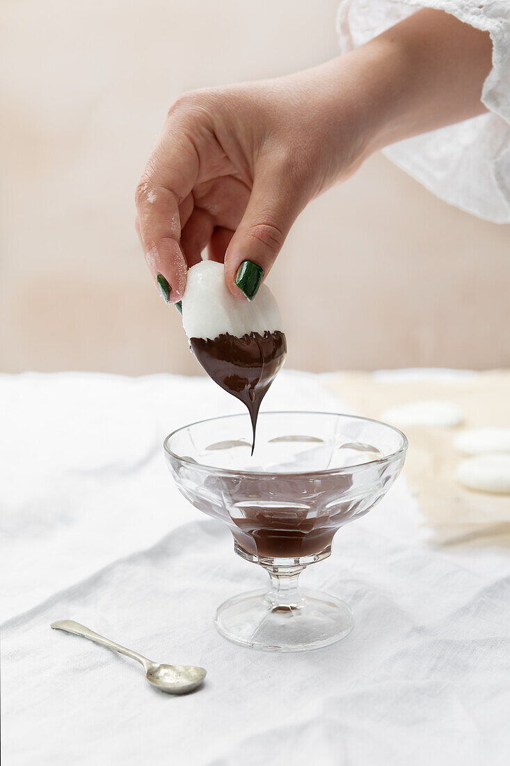 Vegan peppermint creams being dipped in chocolate