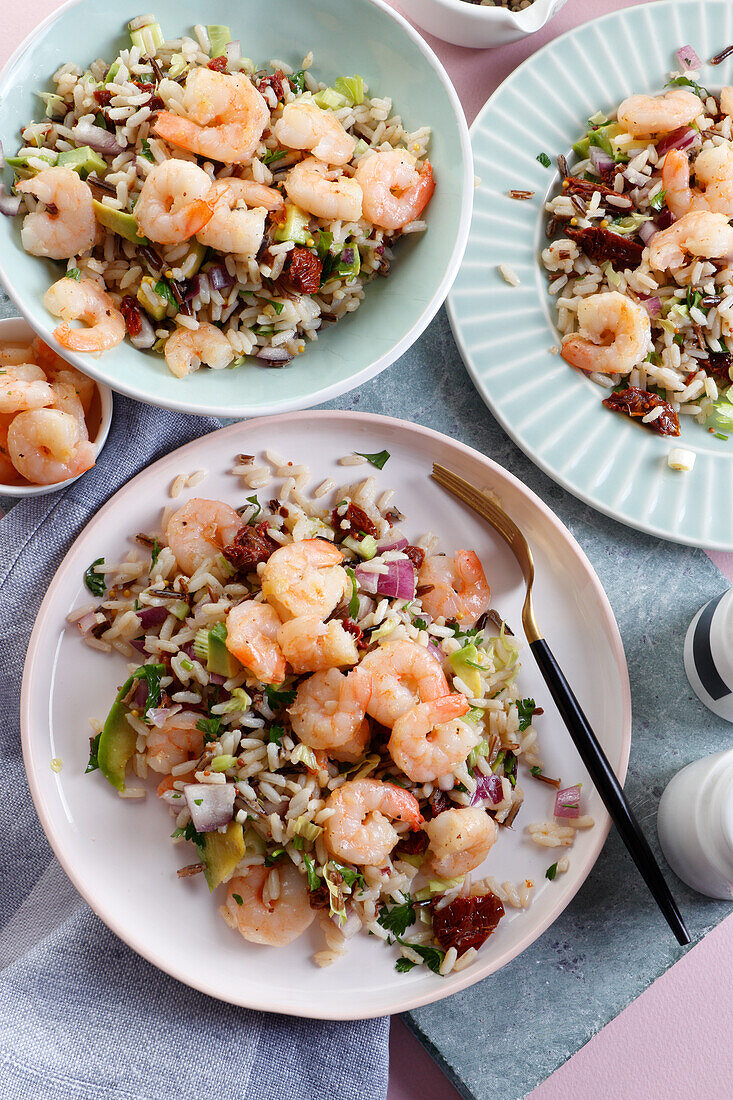 Rice salad with avocado, sun-dried tomatoes, onions and prawns