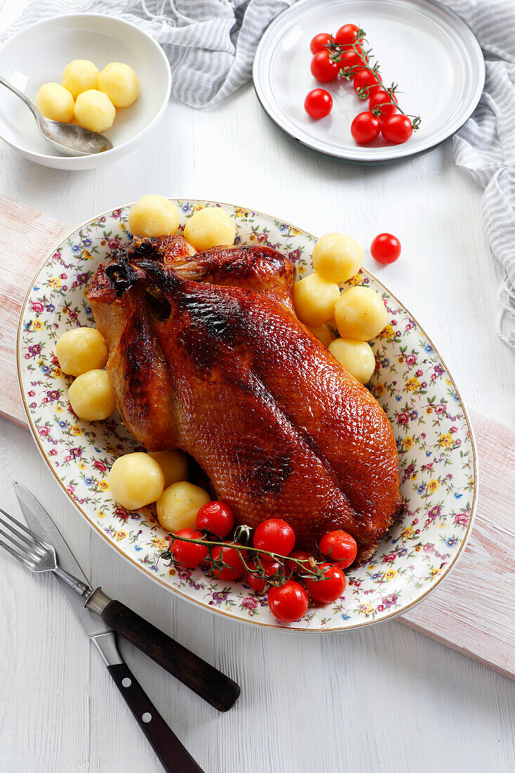 Gebratene Ente mit Kartoffeln und Cocktailtomaten