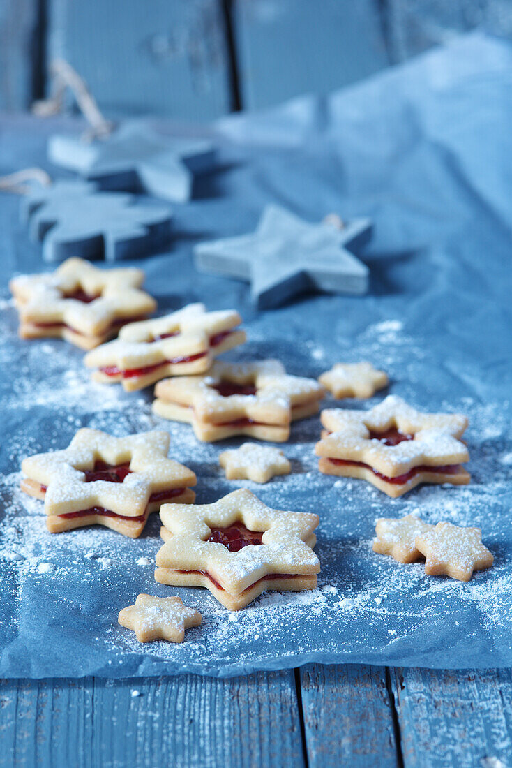Star-shaped jam cookies on a blue background