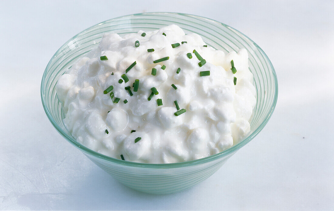 Cottage cheese with chives in a glass bowl