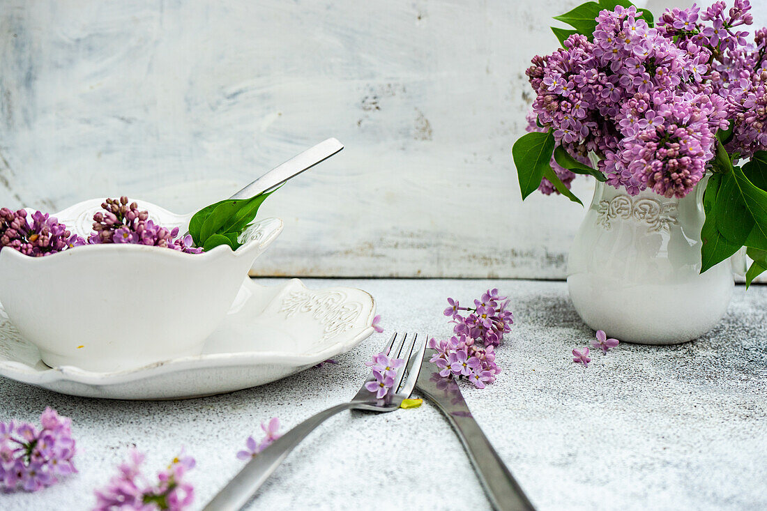 Spring place setting with lilac flowers on outdoor table