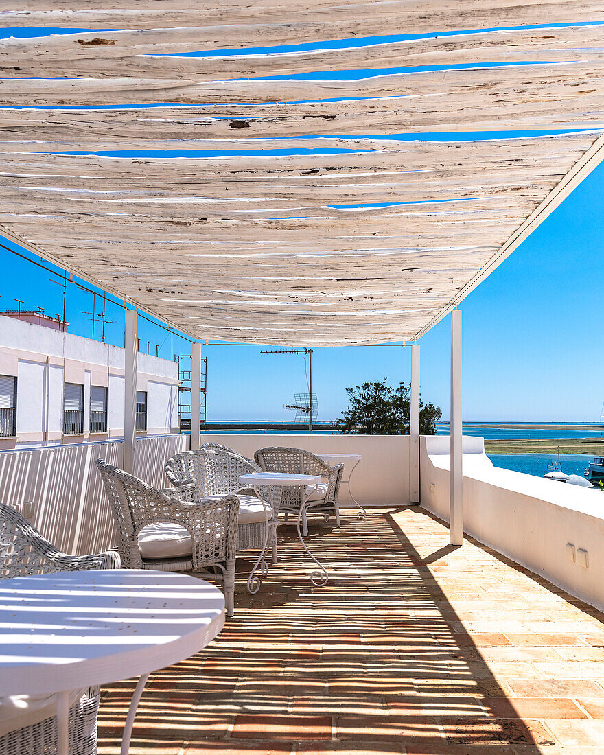 Sun terrace with sea view, rattan furniture and canopy