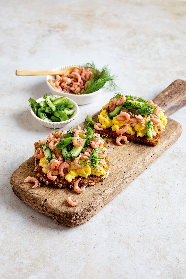 Scrambled egg on toast with shrimps and cucumber