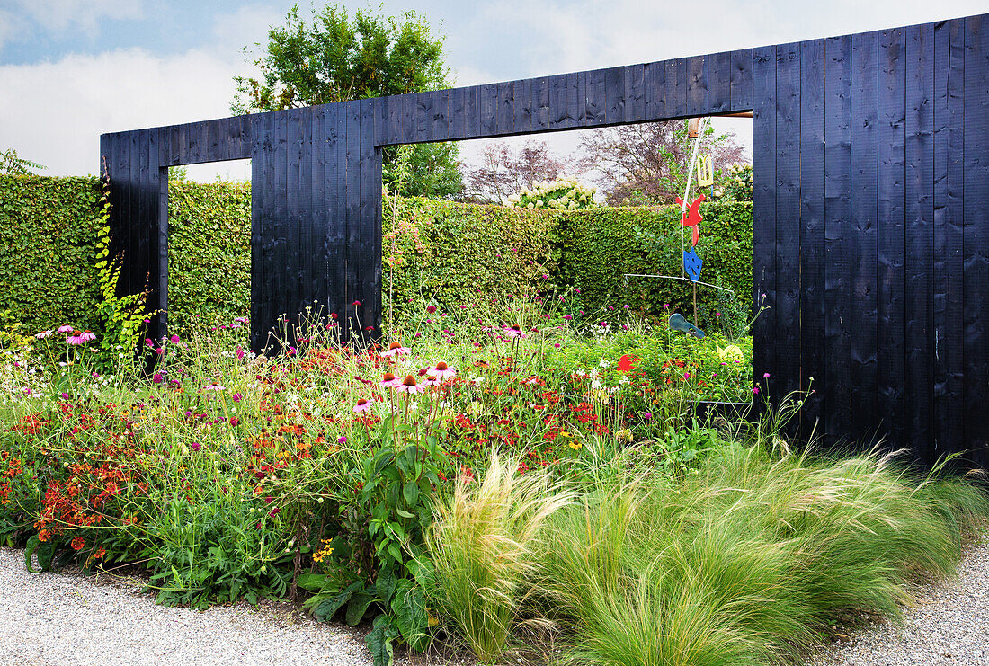 Wooden wall with passage in the flowering garden (Appeltern, Netherlands)