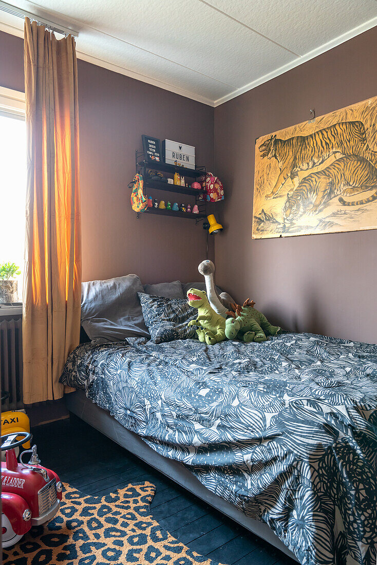 A bed in a boy's room with a muted wall colour