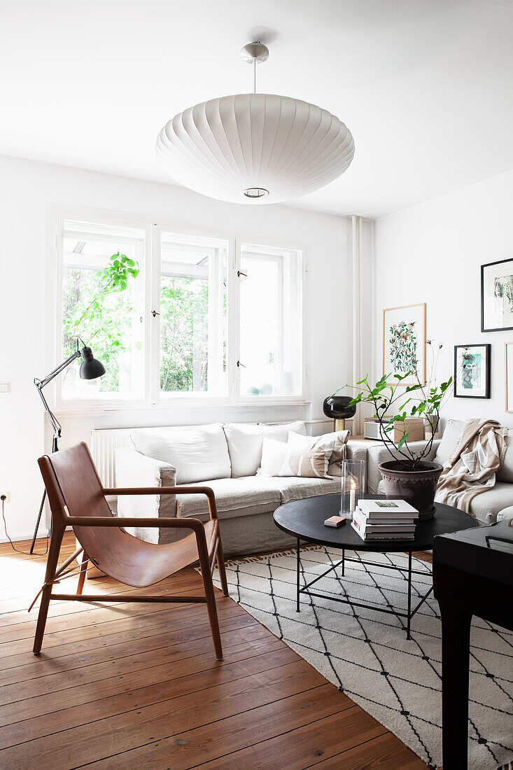 A leather chair, a black coffee table and a light upholstered sofa in a living room