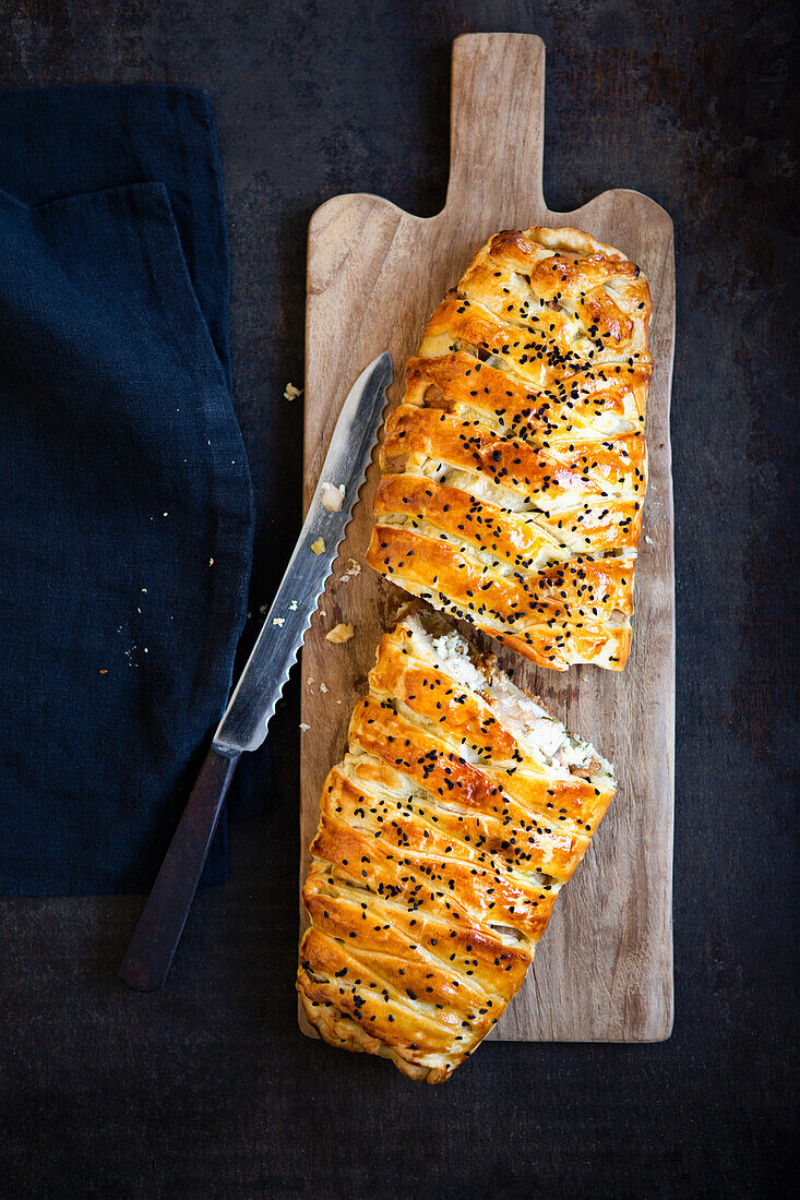 Braided puff pastry with chicken filling and sesame seeds
