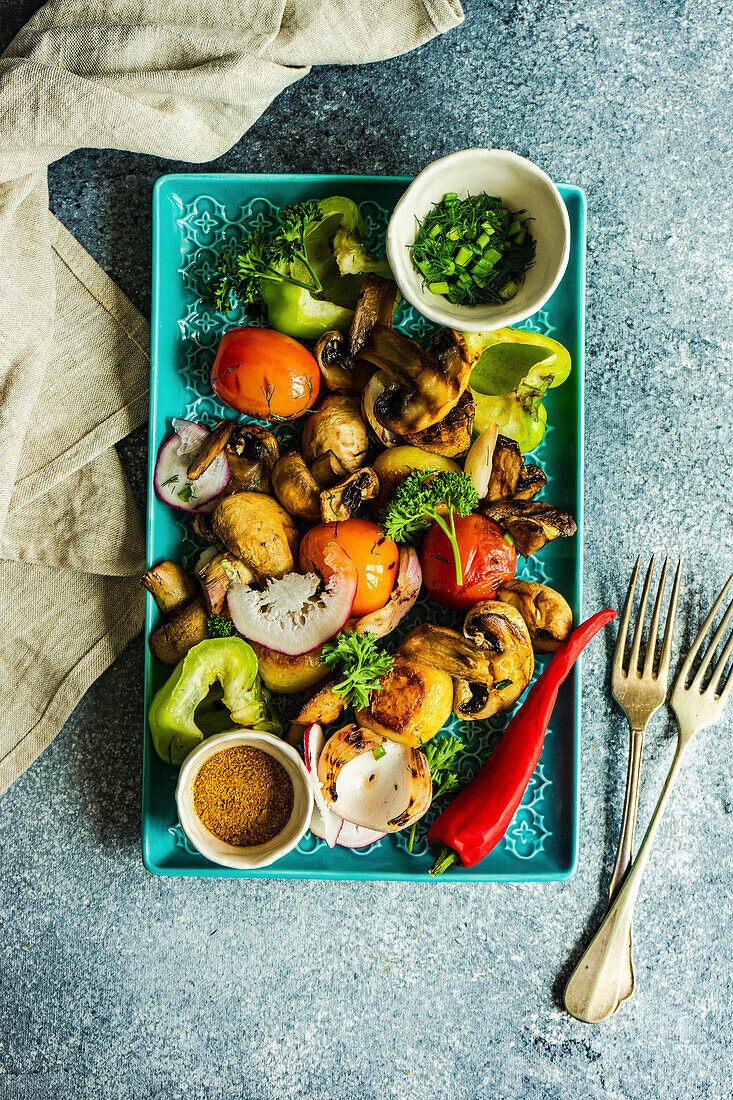 Healthy salad made with organic BBQ vegetables served on plate with herbs and walnut sauce