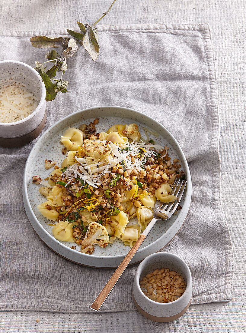 Fried noodles with cauliflower, spring onions and pine nuts