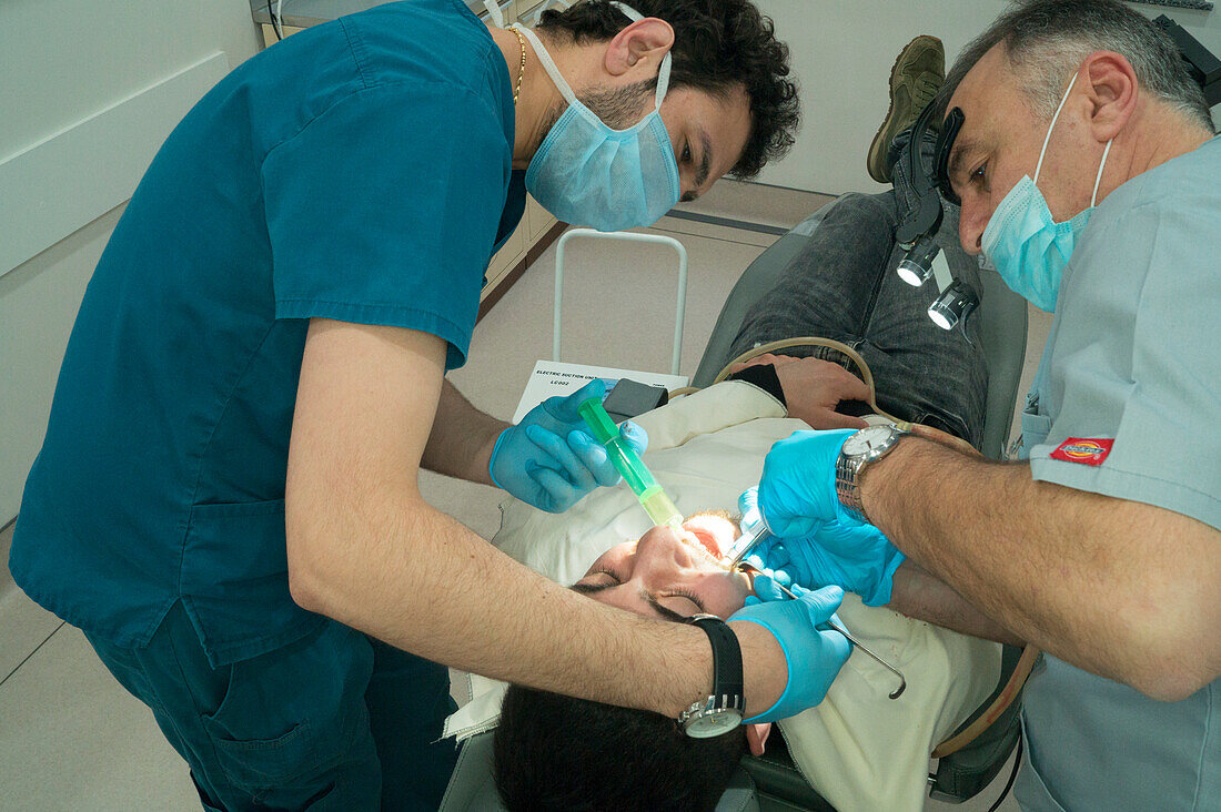 Dentist removing tooth due to a root cyst