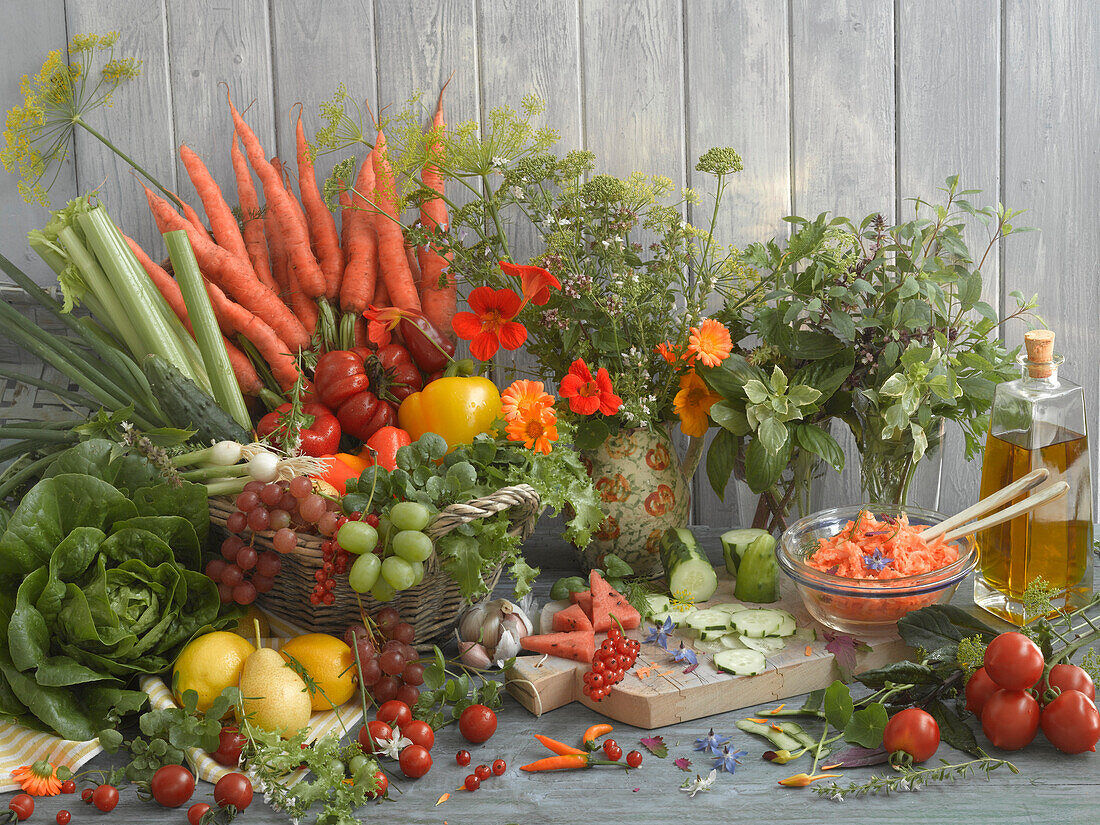 Still life with fruit, vegetables, herbs, olive oil, and carrot salad