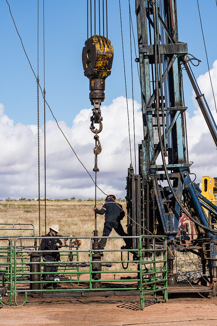 Well service crew on a workover rig on an oil well
