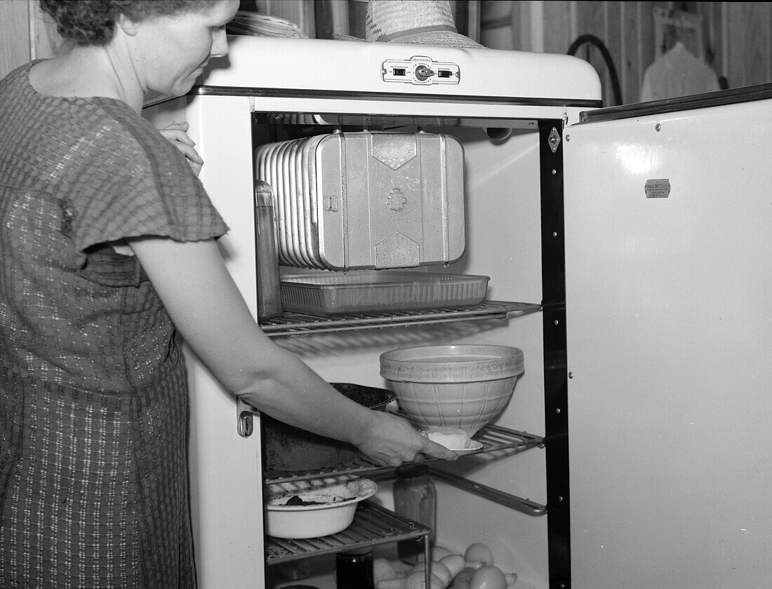 Woman using an electric refrigerator, 1938