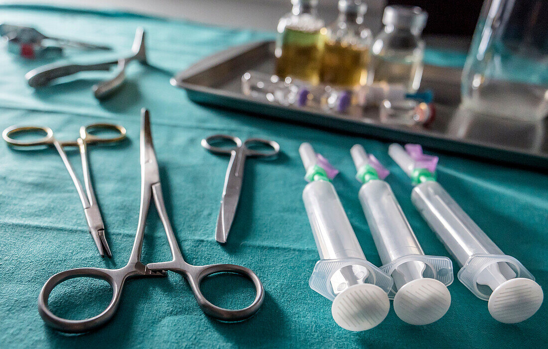 Surgical scissors, syringes and vials on a table