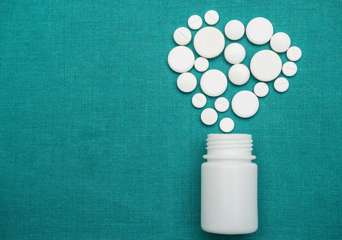 Pills coming out of a white container