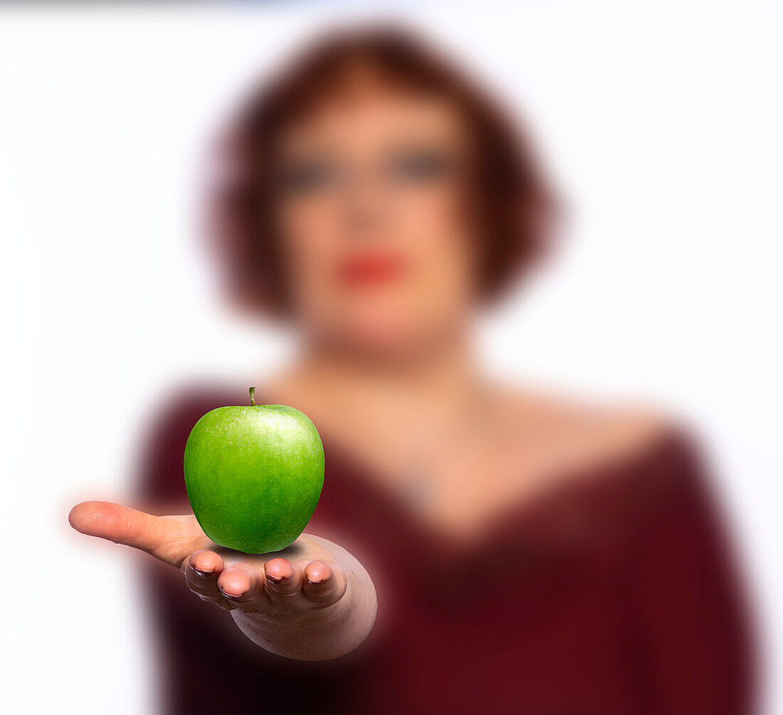 Woman offering a green apple