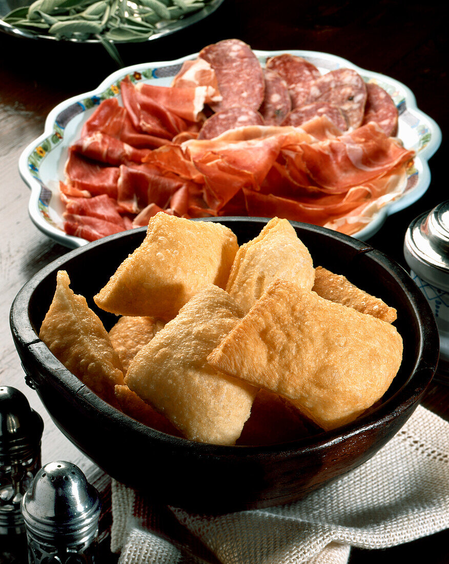 Gnocco fritto (Frittierter Teigfladen, Parma, Italien) mit Salami
