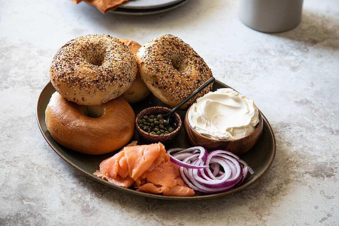 Breakfast tray with bagels, cream cheese, onions, salmon, and capers