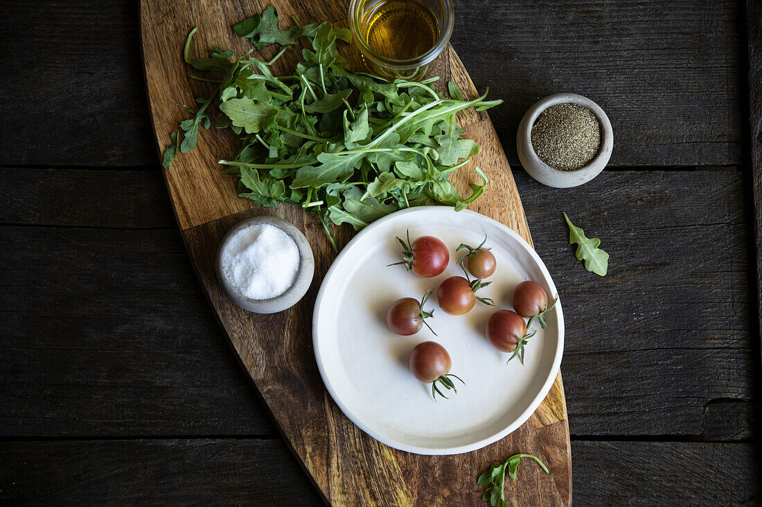 Cherry tomatoes and rocket on wooden board