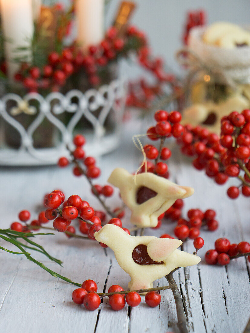 Bird shaped Linzer Jam cookies between holly berries