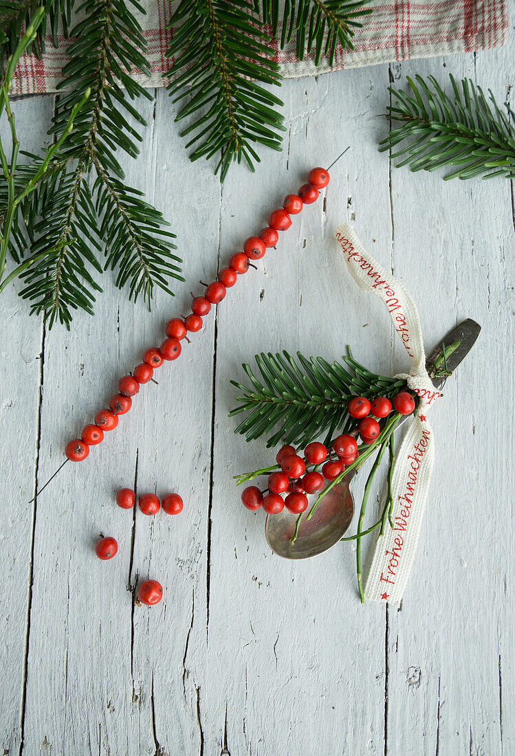 Silver spoon with holly bouquet and Christmas ribbon