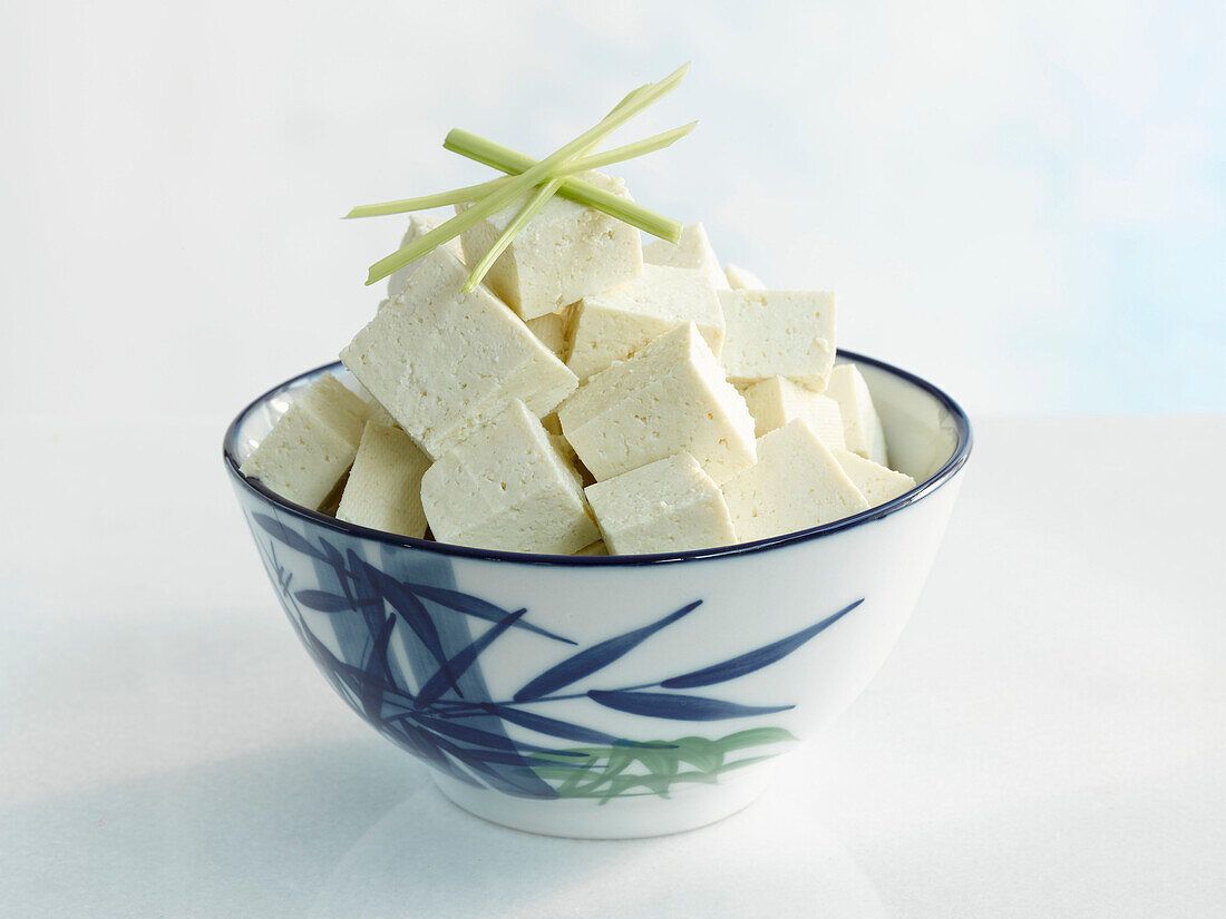 Tofuwürfel in asiatischer Schale vor hellem Hintergrund