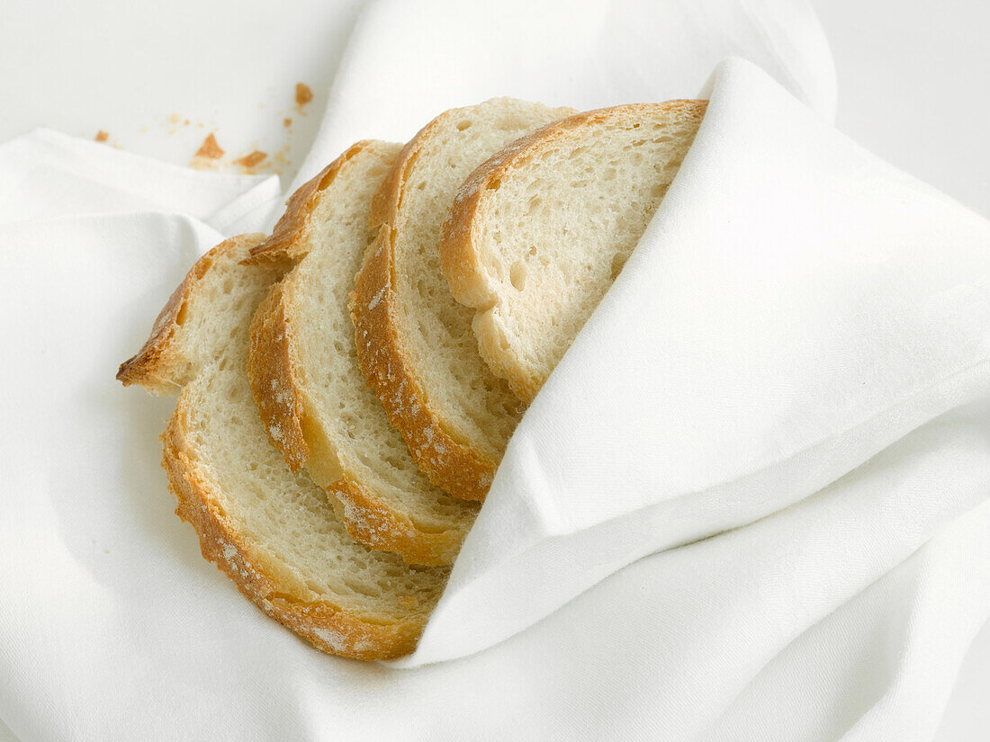 Vier Scheiben Brot in Serviette gewickelt