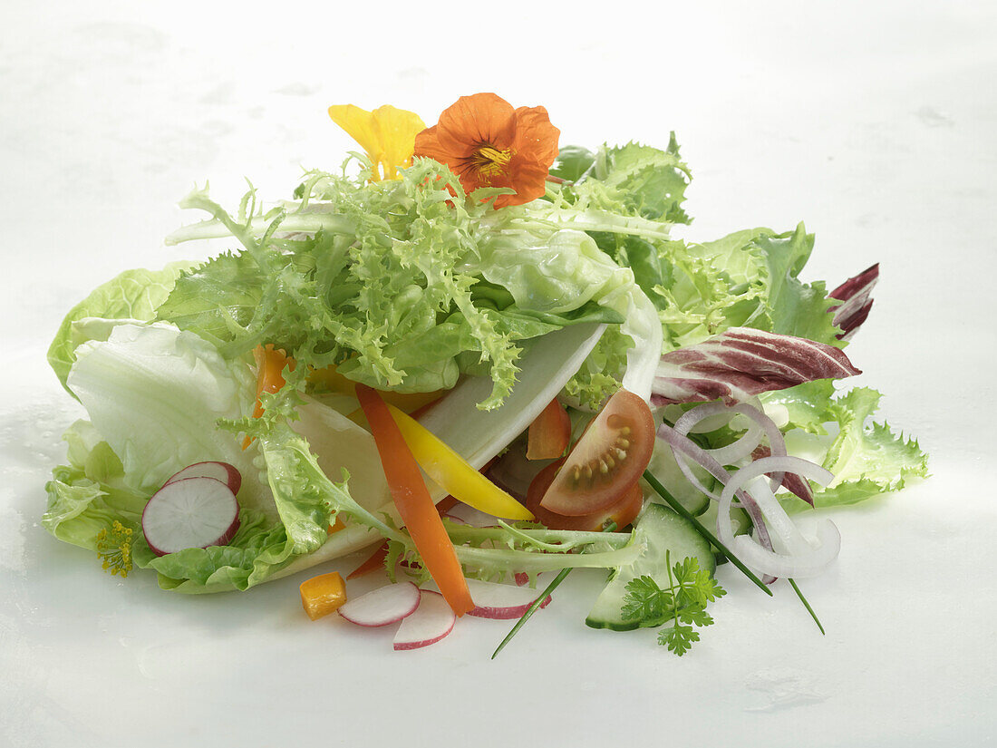 Ein Haufen hellgrüner Salat und verschiedene andere Salatzutaten