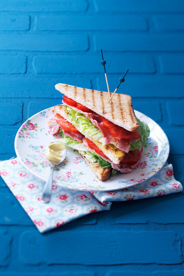 Club-Sandwich mit Speck, Salat und Tomaten