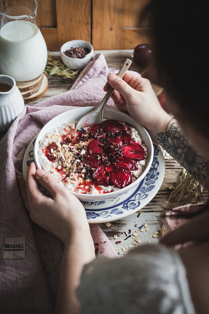 Woman eating porridge with plums