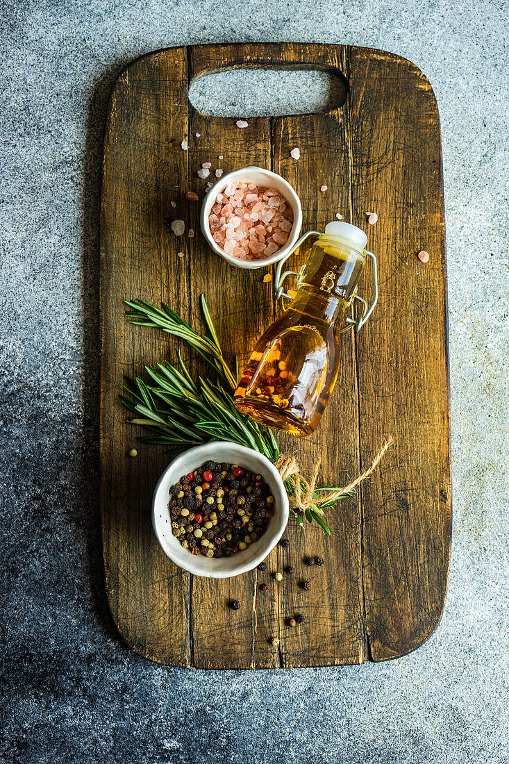 Spices, rosemary and oil on a wooden board