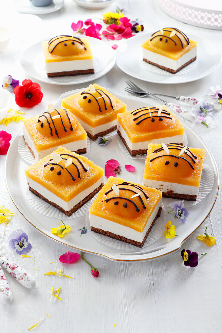 Cheesecake with peach mousse and peach halves, decorated like bees